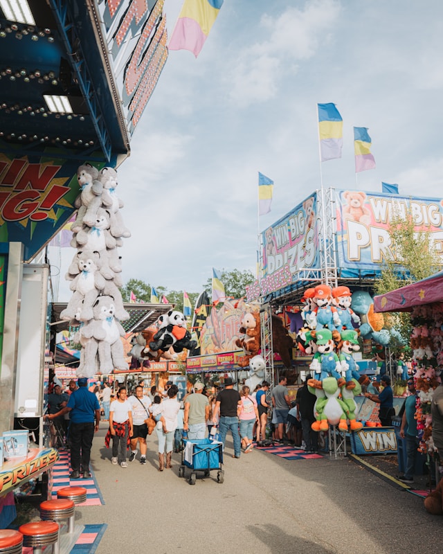 Crowded carnival midway with outdoor fair game booths